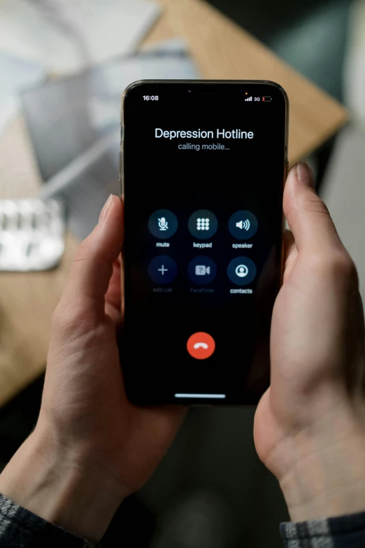 a person using a cell phone while sitting at a desk