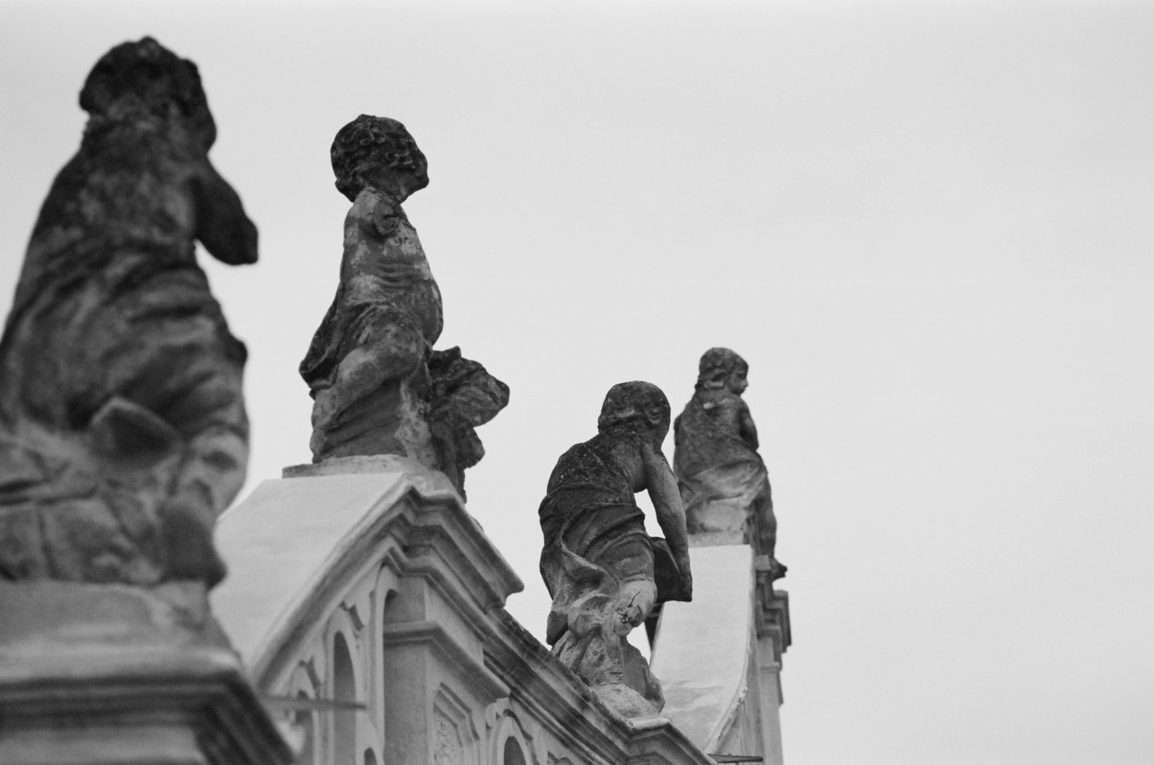 several statues and buildings with a white sky in the background