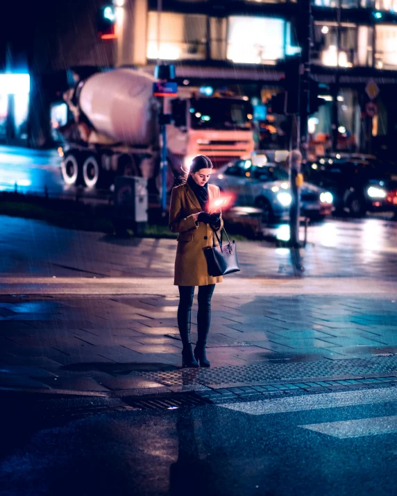 the woman is looking at her cell phone on the street corner