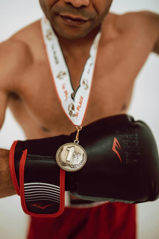 close up of boxer in red shorts with medal