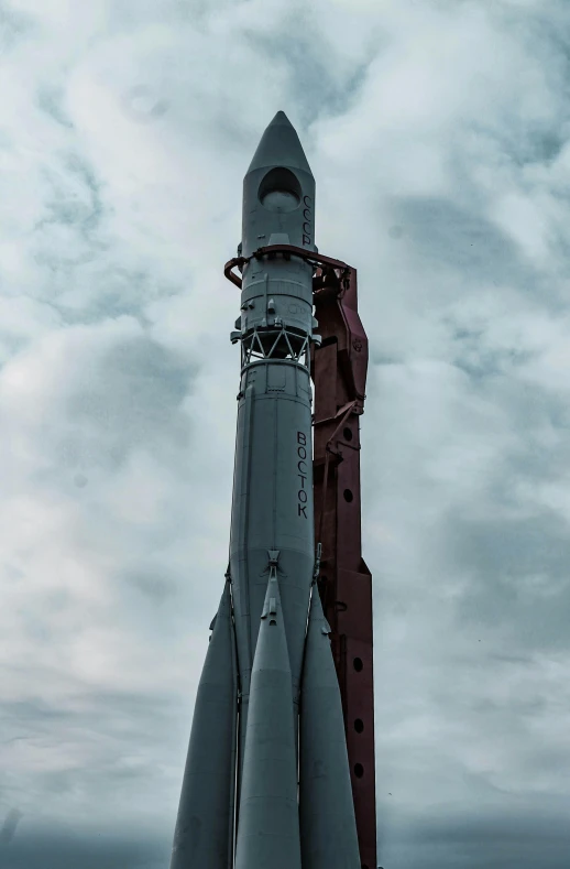 an old saturn rocket sitting next to another ship