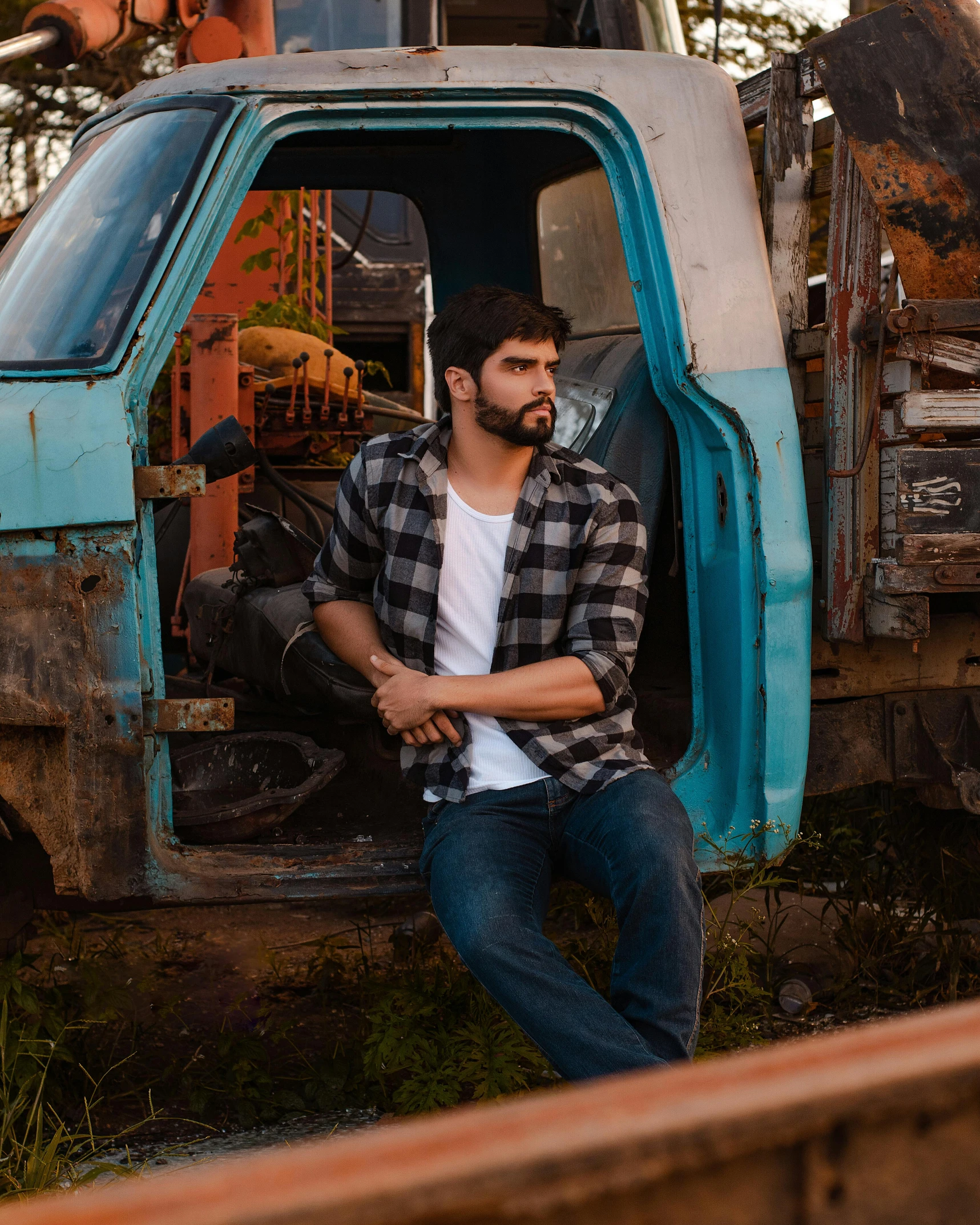 the man is sitting outside on the old truck