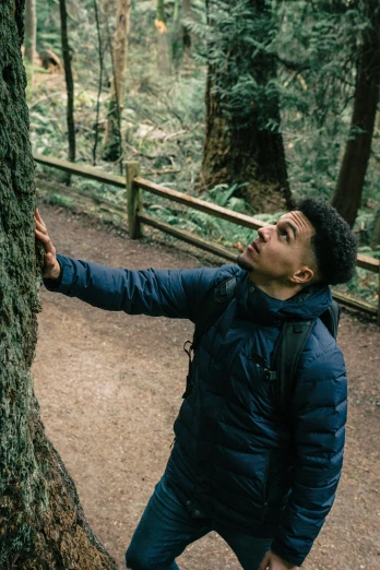 the person is leaning on a tree in the woods