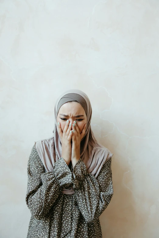 young muslim woman covered by head covering in hands