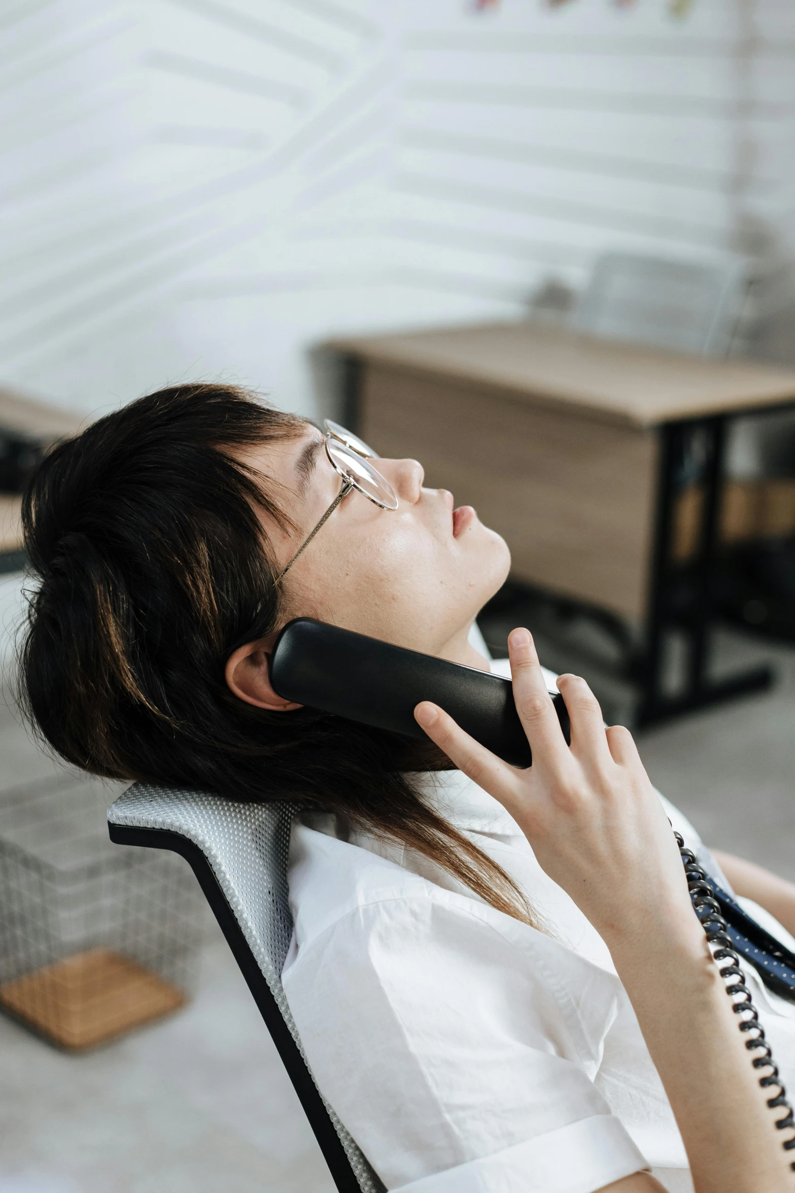 a woman in white shirt on cell phone with headphones