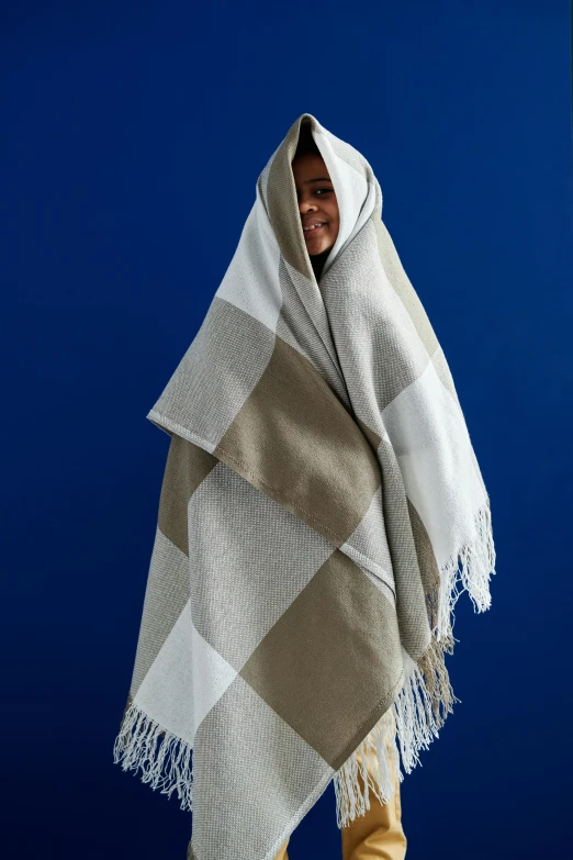 a person wrapped in a large blanket and smiling