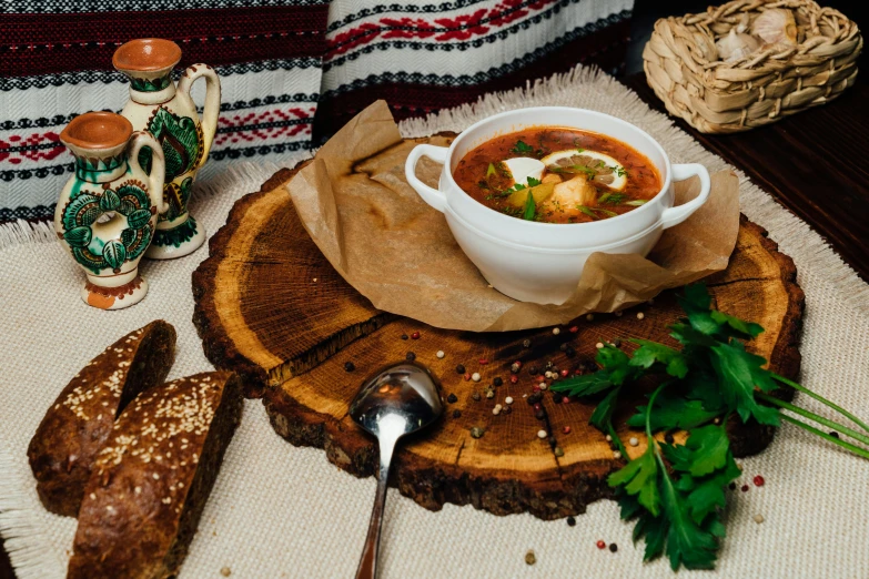 a bowl of soup is sitting on top of a slice of wood