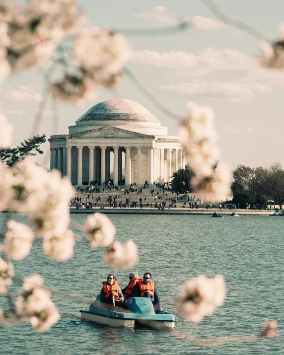 a boat that is in some water with a building behind it