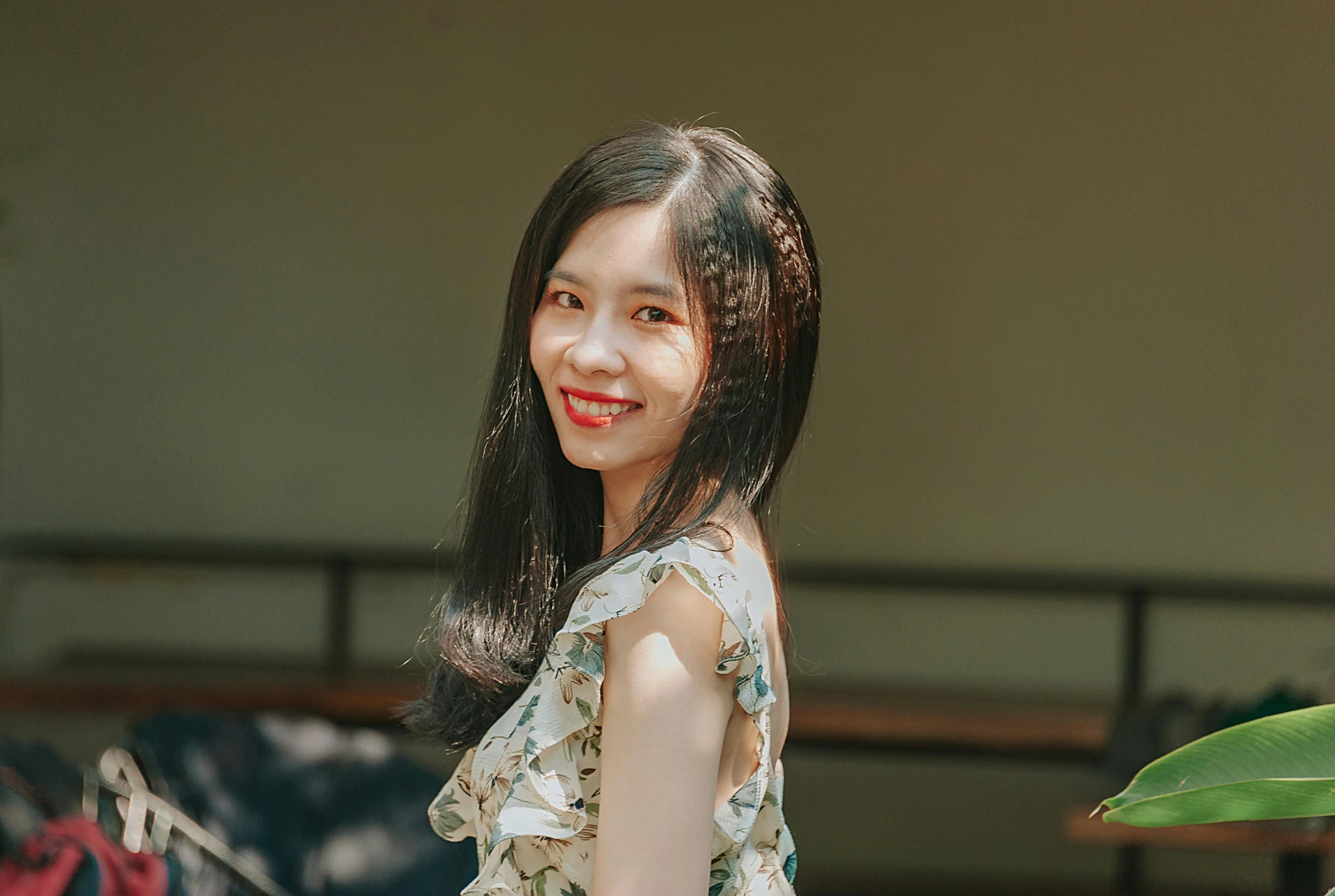 an asian woman wearing a floral shirt is smiling