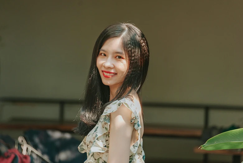 an asian woman wearing a floral shirt is smiling