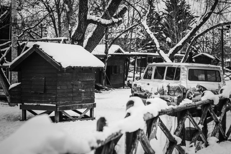 the old camper is parked on the fence covered in snow