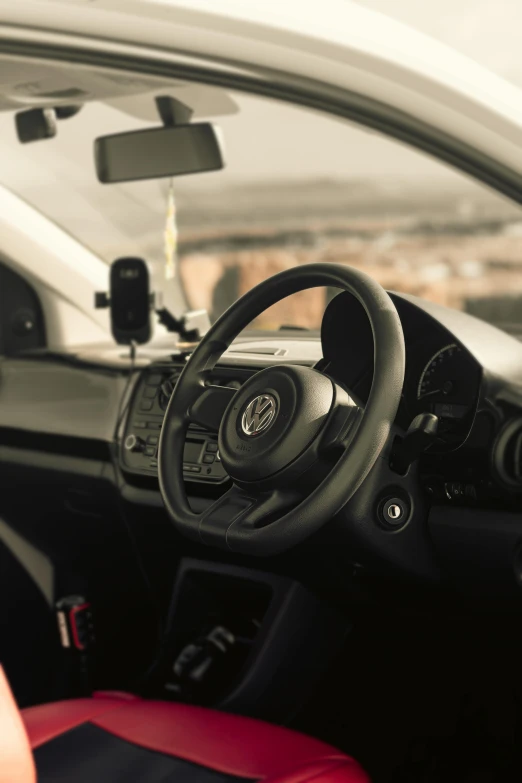 dashboard and steering wheel on an automobile with dashboard view mirror in background