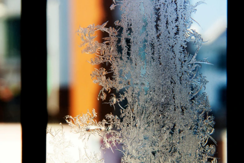 a frosty window with some small snowflakes