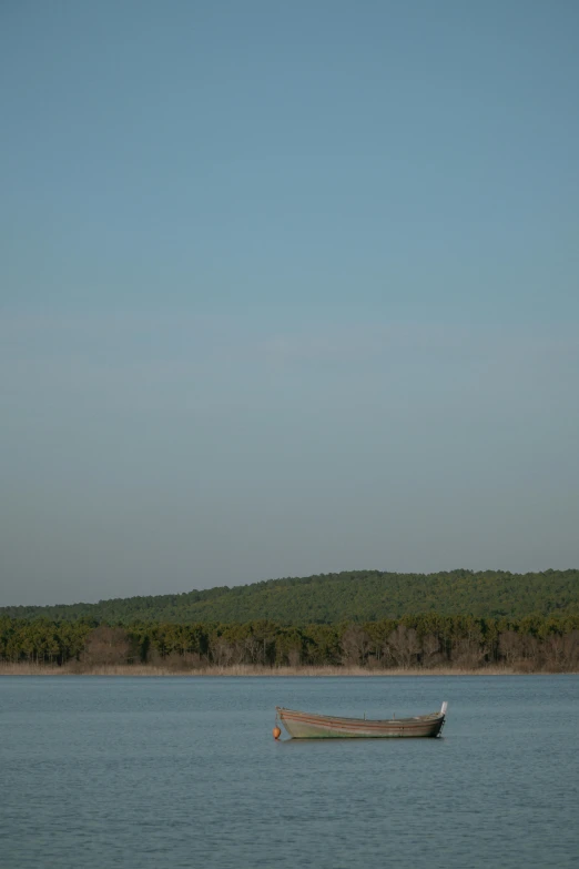 a lone boat is floating on the blue water