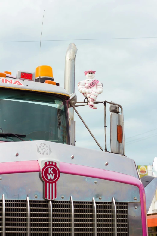 an older pink and grey truck parked at a curb