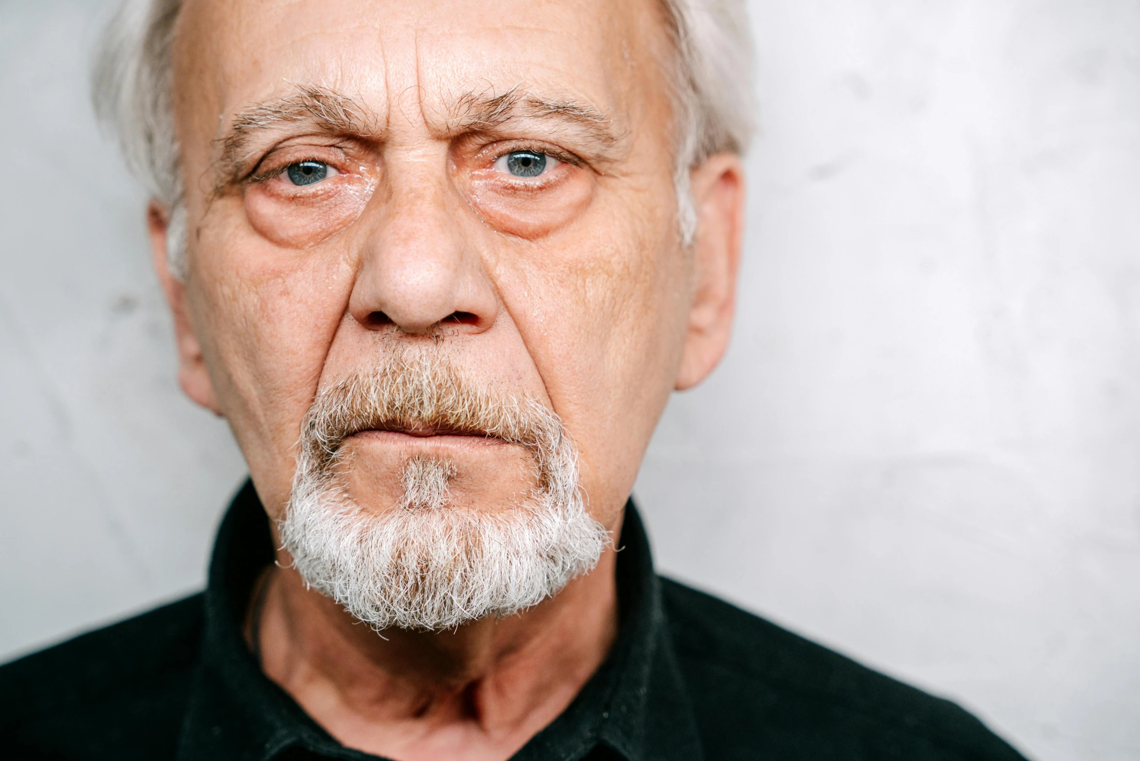 an older man with a white beard is posing for a po