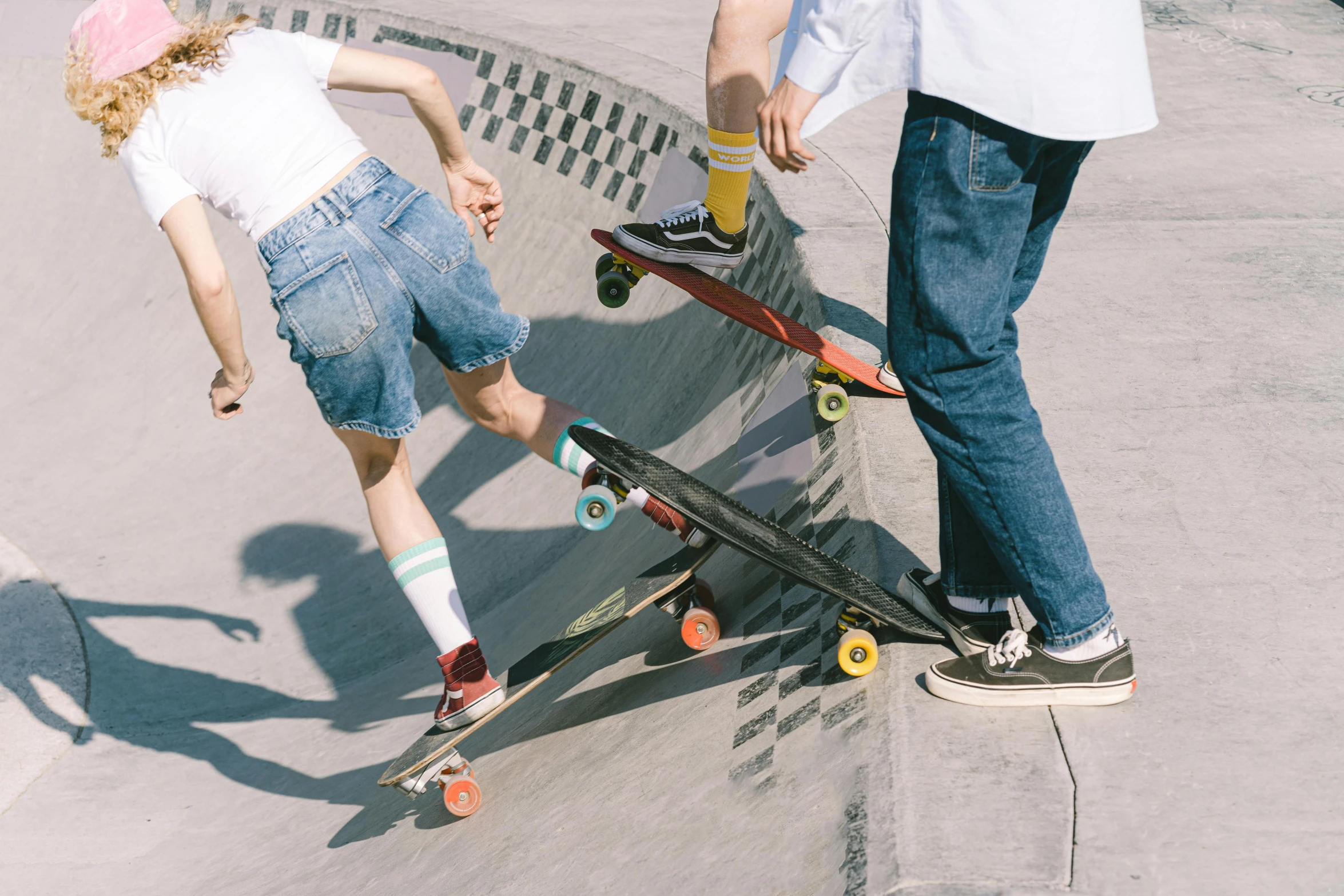 two people in white shirts and one person standing on a skateboard