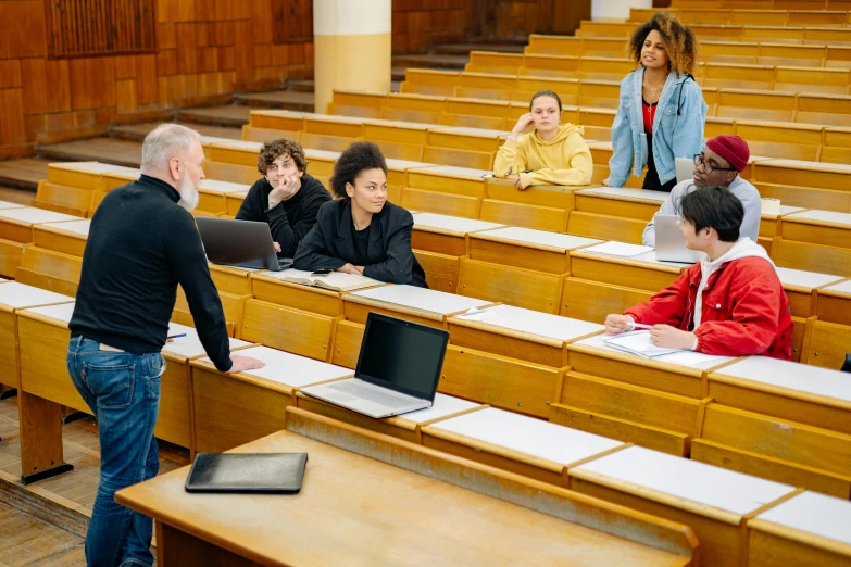 students are being watched by a teacher in a large lecture hall