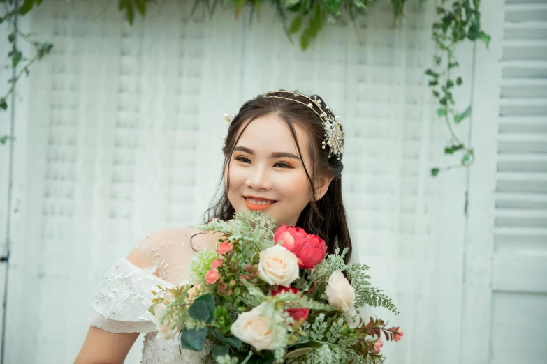 a smiling young woman holding a bouquet of flowers