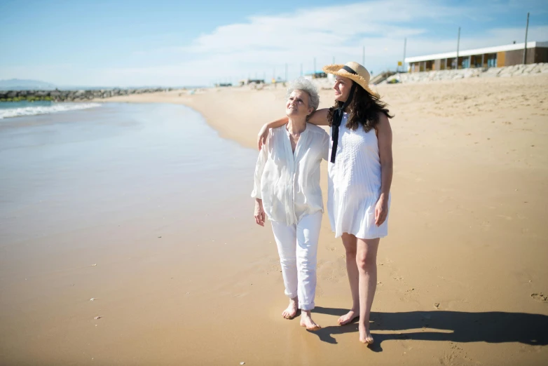 a couple of women walking along a beach