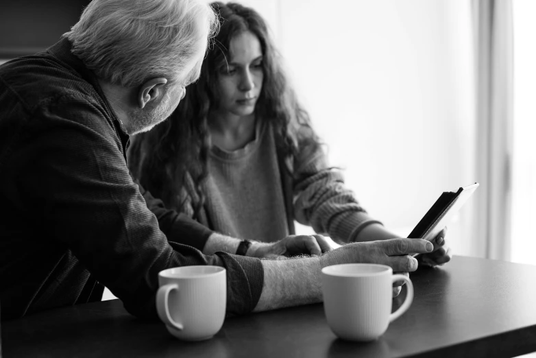 two people looking at their cell phones at a table