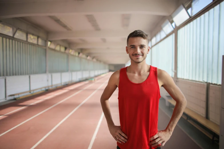 man in a bright red tank top posing for a po