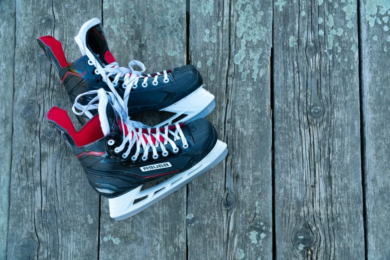 pair of sneakers with laces on sitting against a wooden deck