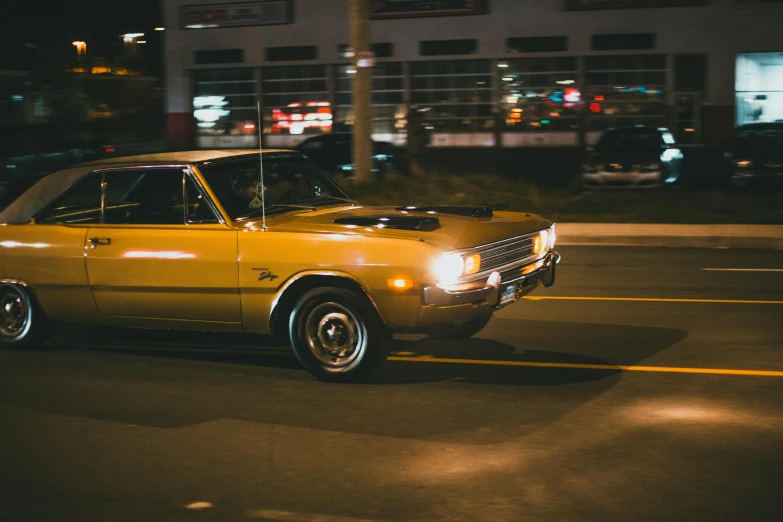 an old yellow car is parked in a parking lot