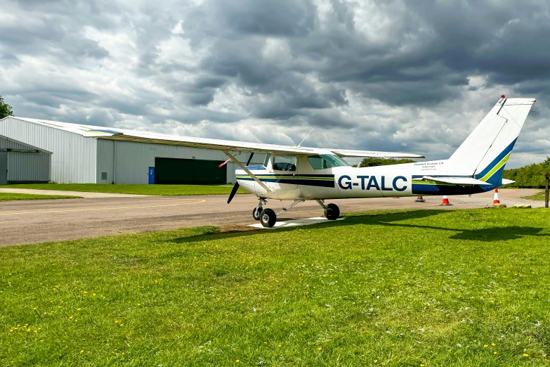 small plane sitting in an airport runway with its wheels down