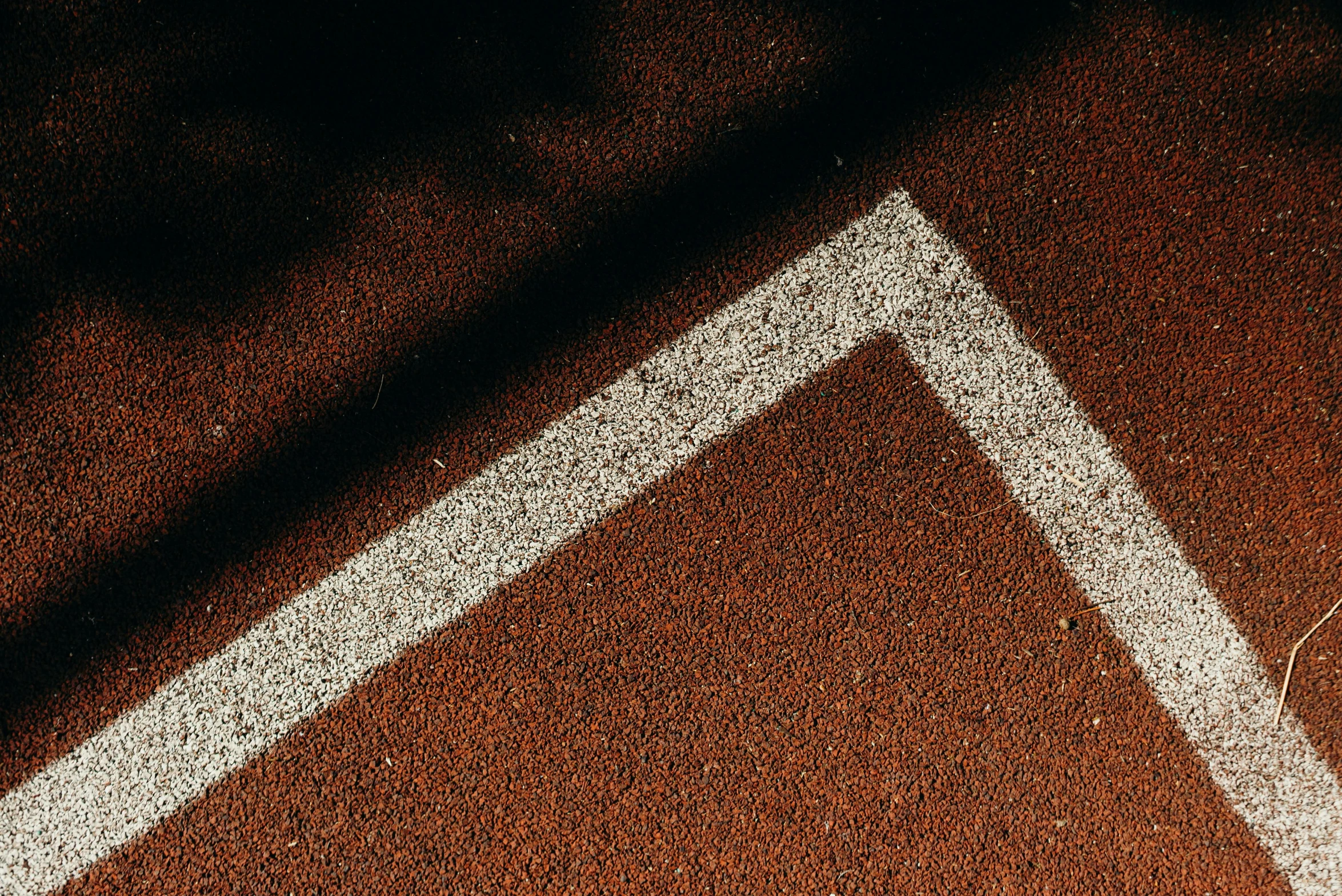 the shadow of a tennis player on an orange court