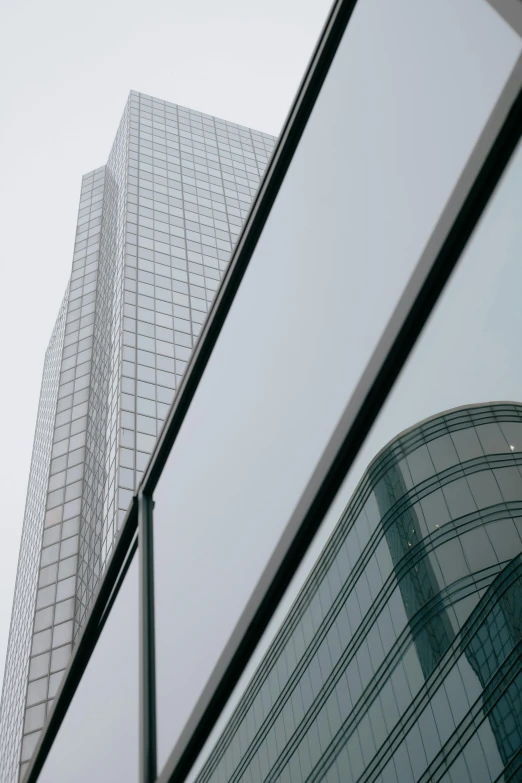 the reflection of a building with another building and one of its windows