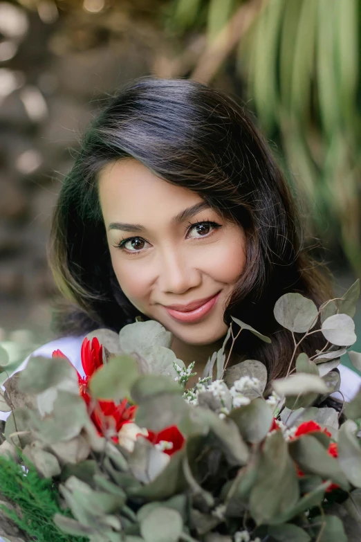 a young woman is smiling while holding a bouquet of flowers