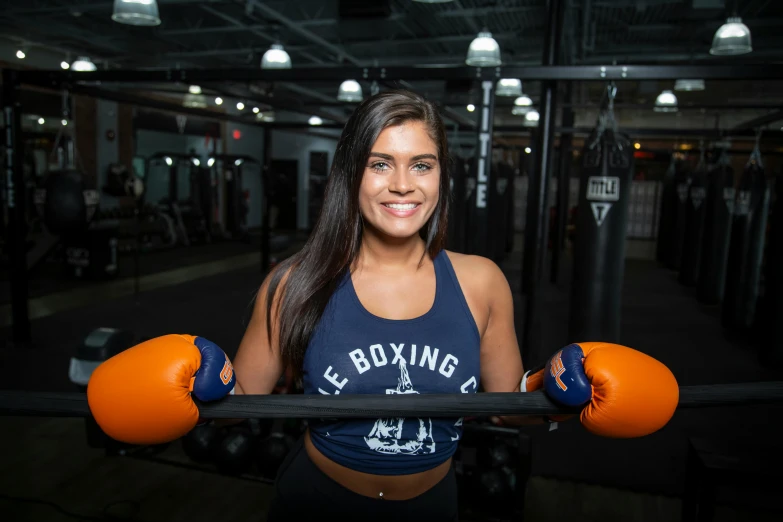 woman with red boxing gloves and boxing gloves on her shoulders