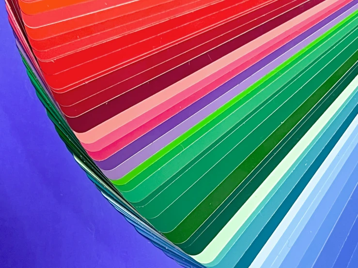 multiple rows of colored strips of material on purple background