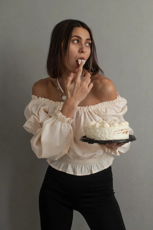 a woman holding a cake and looking away from her face