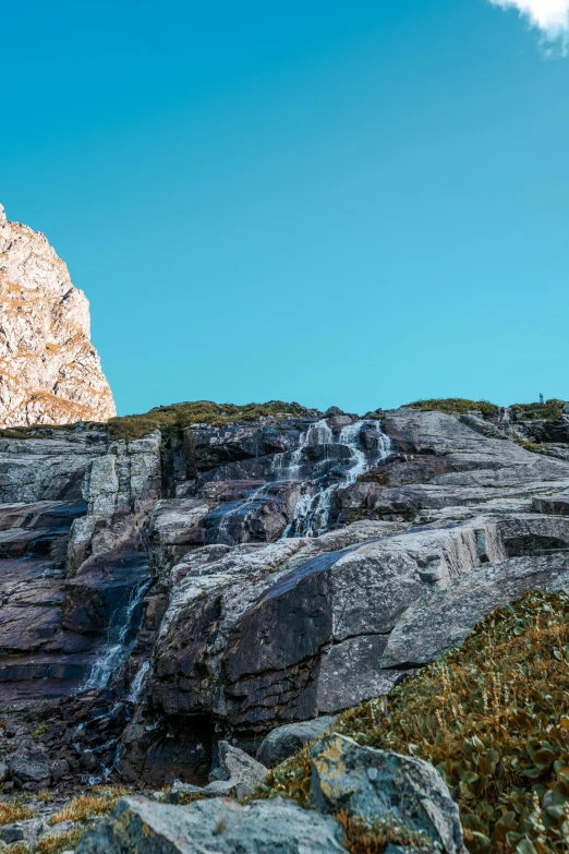 the view is looking up at a large rock mountain