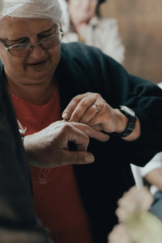 an older person is holding soing in her hands