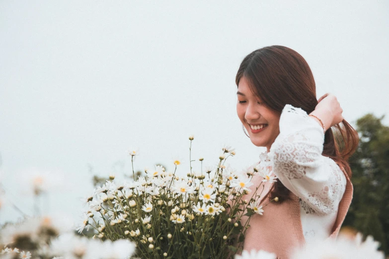 a young woman smiles at her friend in front of some wild flowers