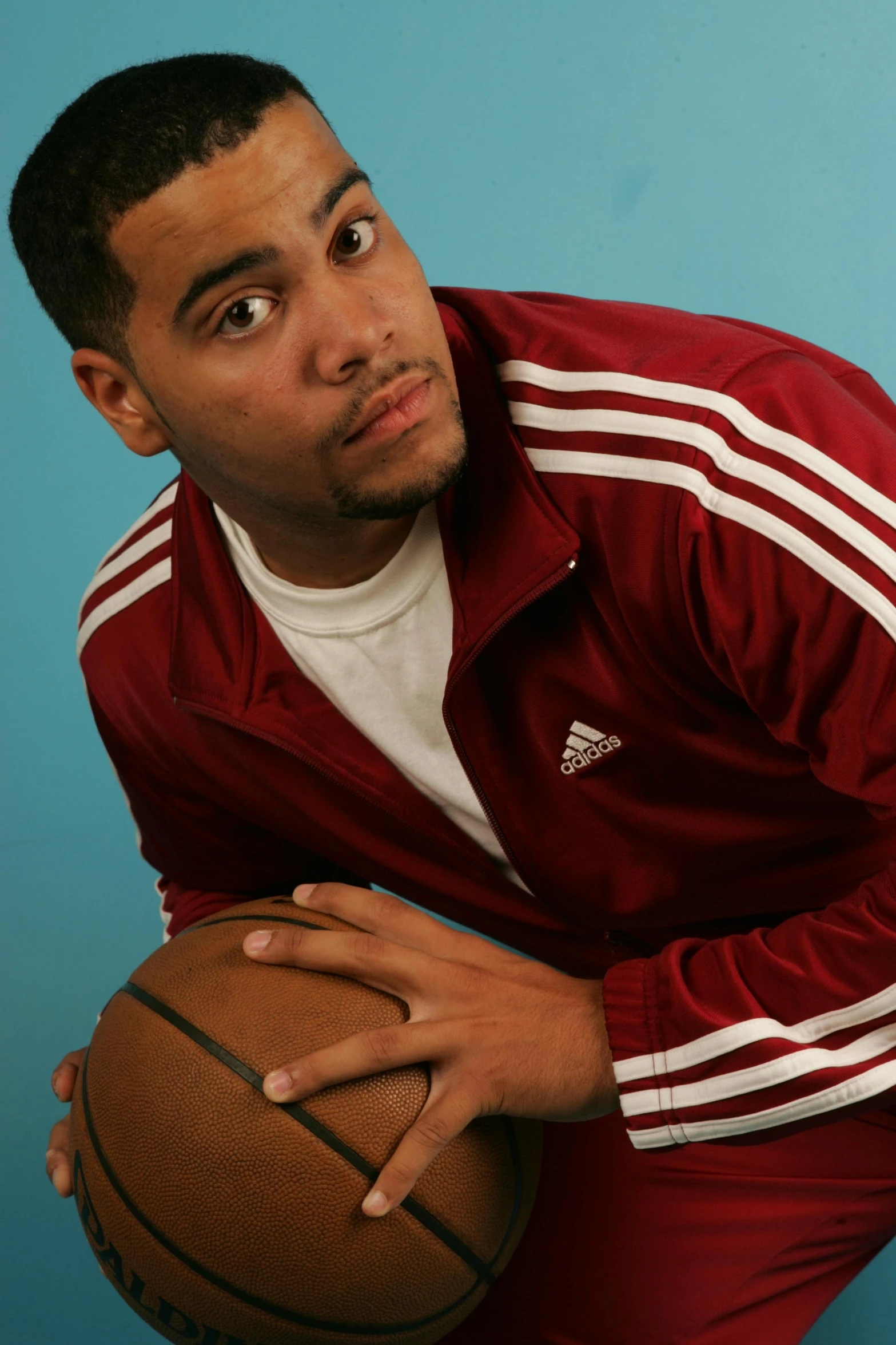 a man is holding a basketball and smiling