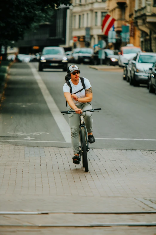 a young man riding a bicycle on the sidewalk of a city