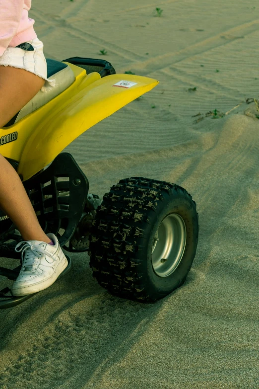 a person is riding a small motorcycle in the sand