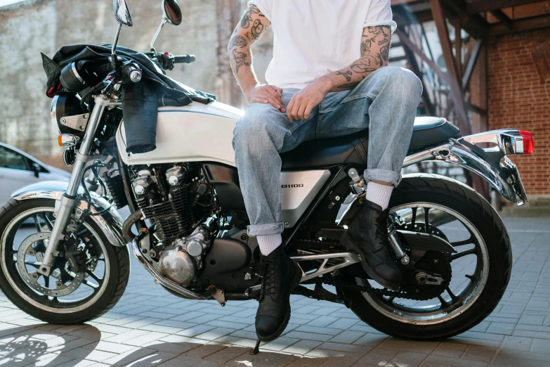 a man with a tattoo sitting on top of a motorcycle