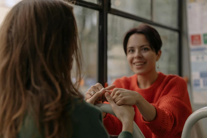 woman getting the finger of another woman on her thumb