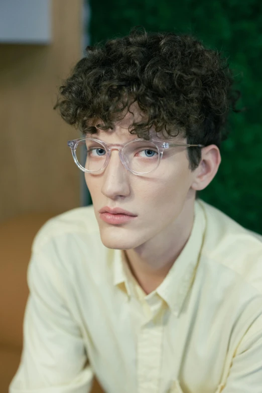 a young man with glasses and blonde shirt