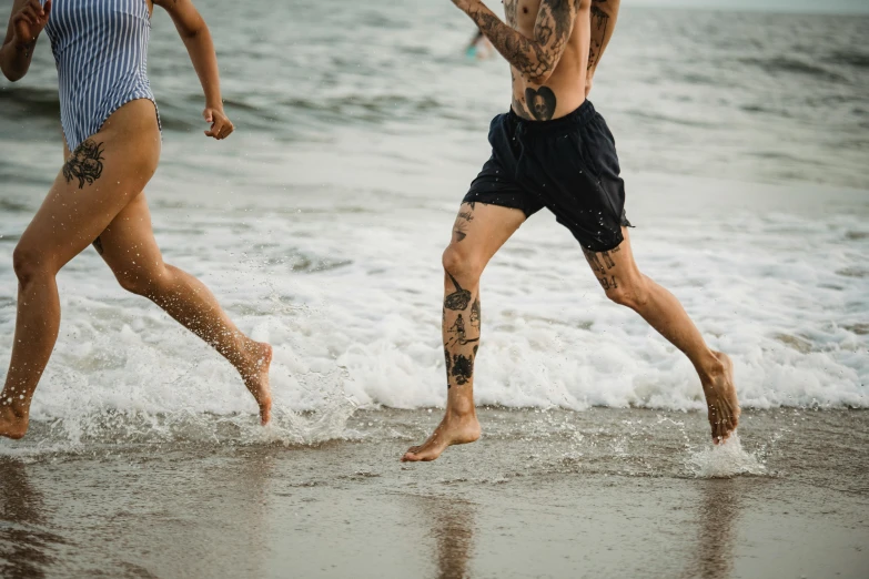 two people running in the surf while they both jump