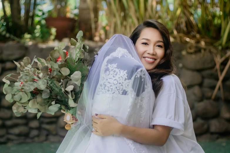 a woman in a white wedding dress is hugging a groom