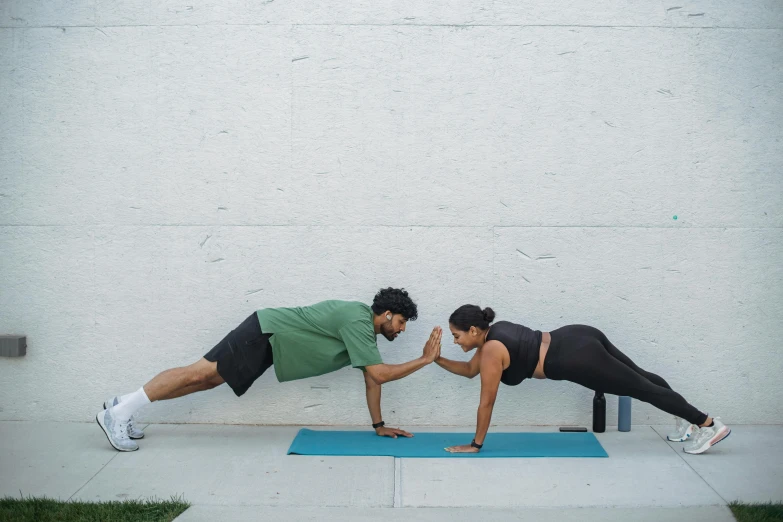 two people doing h ups with a yoga mat