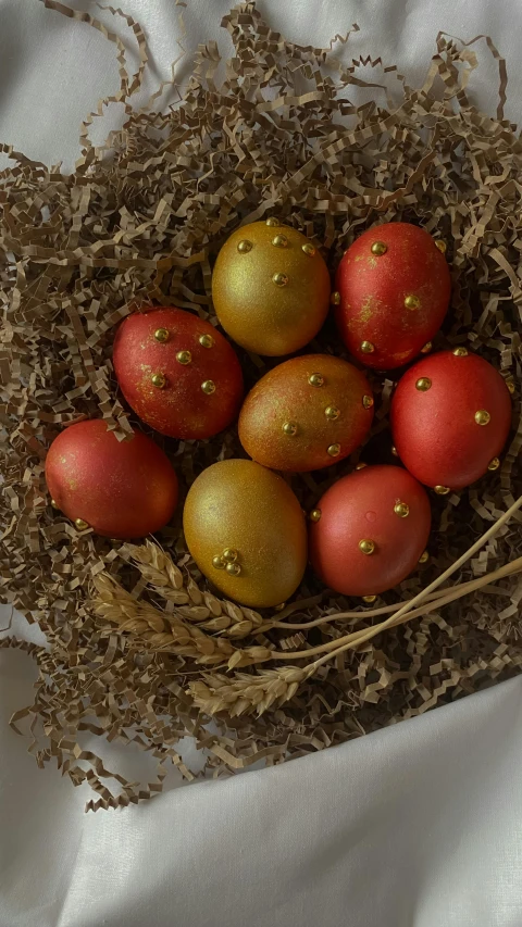 five different colored and brown painted eggs inside a basket