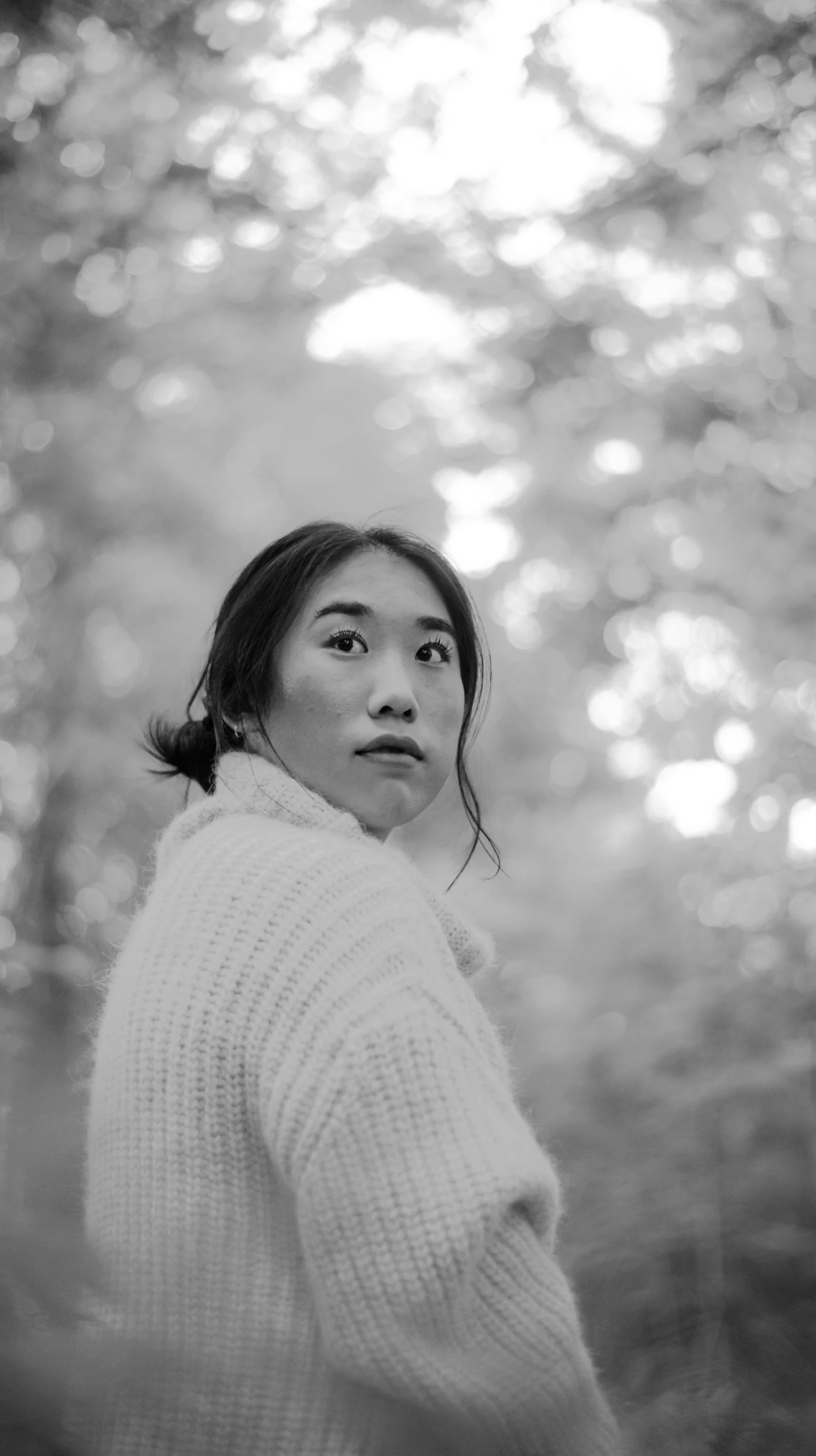 black and white portrait of woman in front of trees