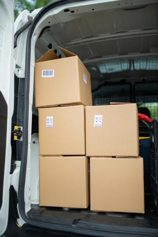 several brown boxes stacked on top of each other in the back of a van